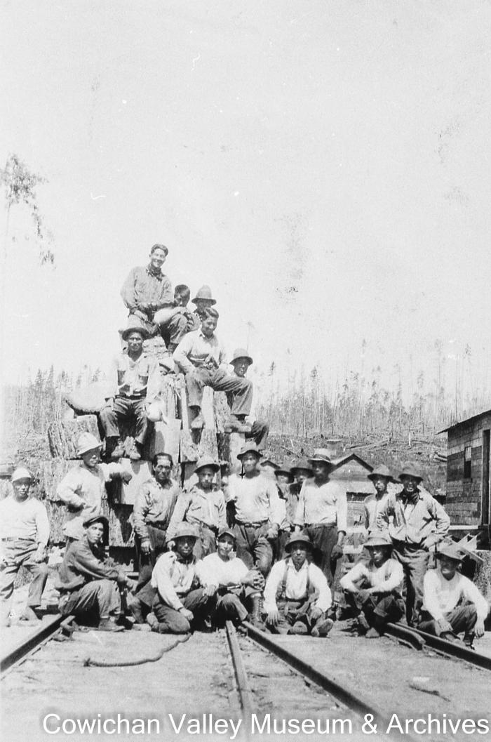 [Unidentified group of workers posing on the railroad tracks]