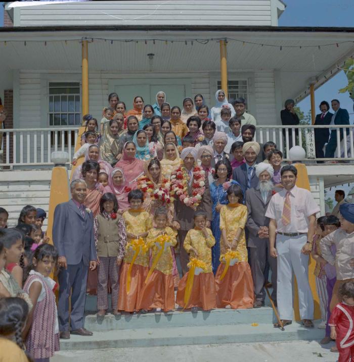 [Photo of Nash Gill and Rajinder Thind with their family members]