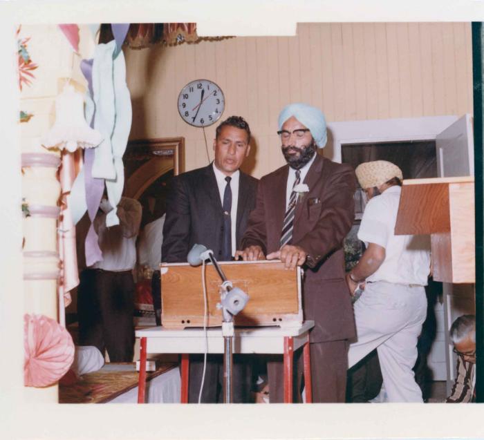 [Photo of of a man playing the harmonium]