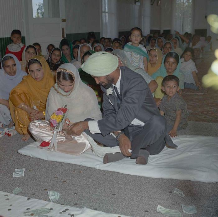 [Photo of Gurmail Singh Sidhu and his wife]