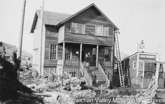 [New store and post office with an unidentified man on the front steps]