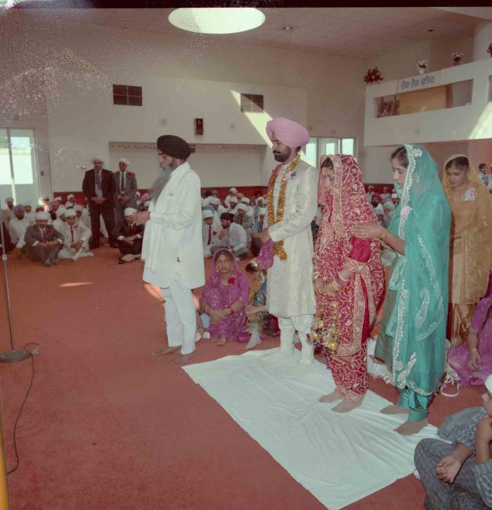 [Group photo of Nav Sunner and Parmvir Mann with wedding guests]
