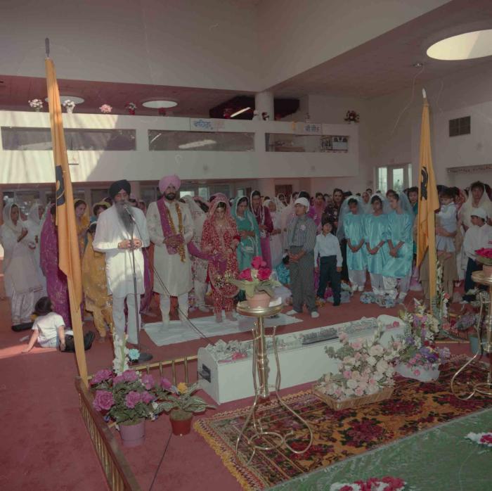 [Group photo of Nav Sunner and Parmvir Mann with wedding guests]