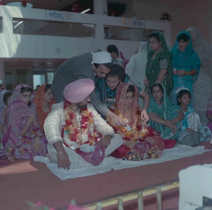 [Group photo of Nav Sunner and Parmvir Mann with wedding guests]