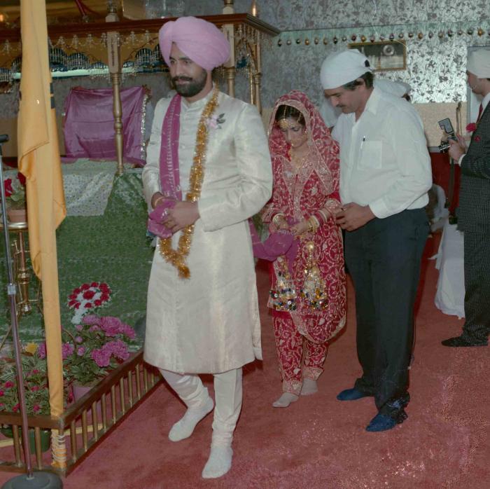 [Group photo of Nav Sunner and Parmvir Mann with wedding guests]