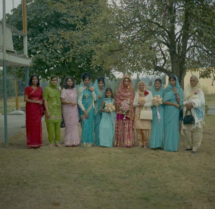 [Photo of Malkit Gill standing with her family members]