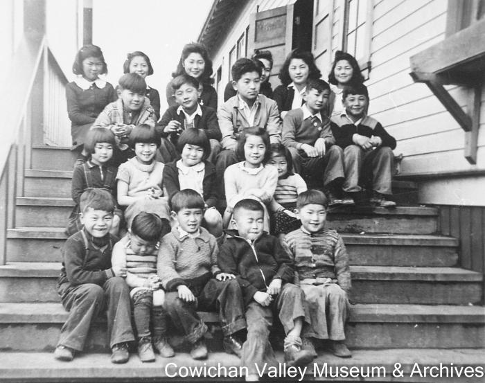 [Unidentified group of children sitting on outdoor steps]